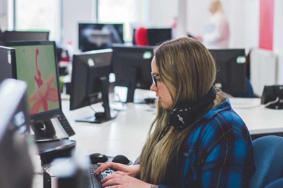 team member sitting at desk working on a social platform