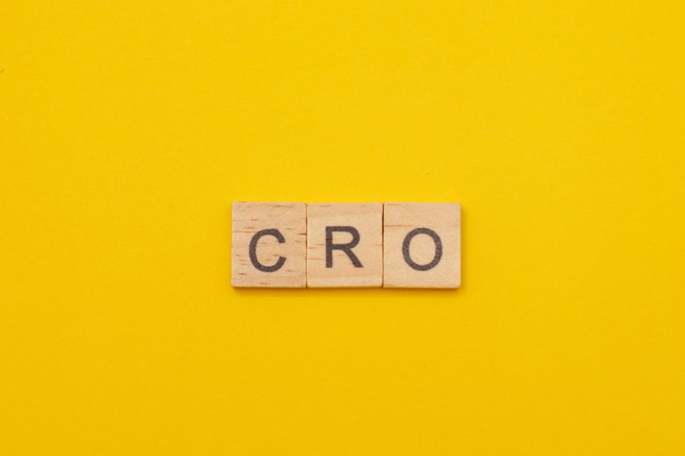 Wooden Scrabble tiles spelling out ‘CRO’ on a yellow background. 